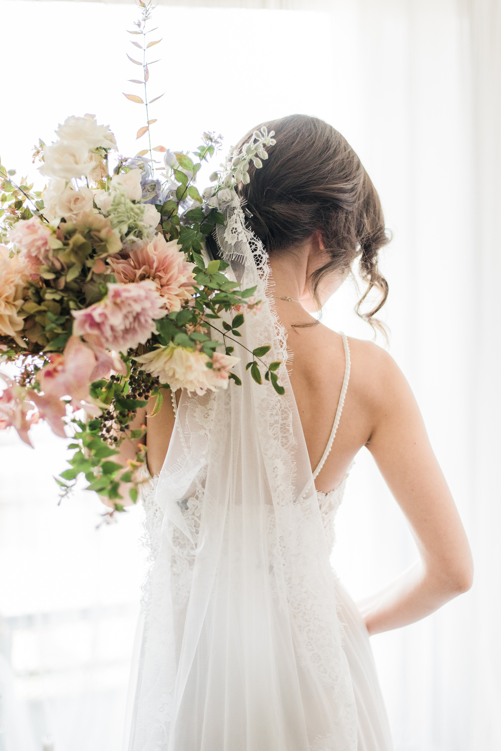 Woman in White Floral Wedding Dress Holding Bouquet of Flowers